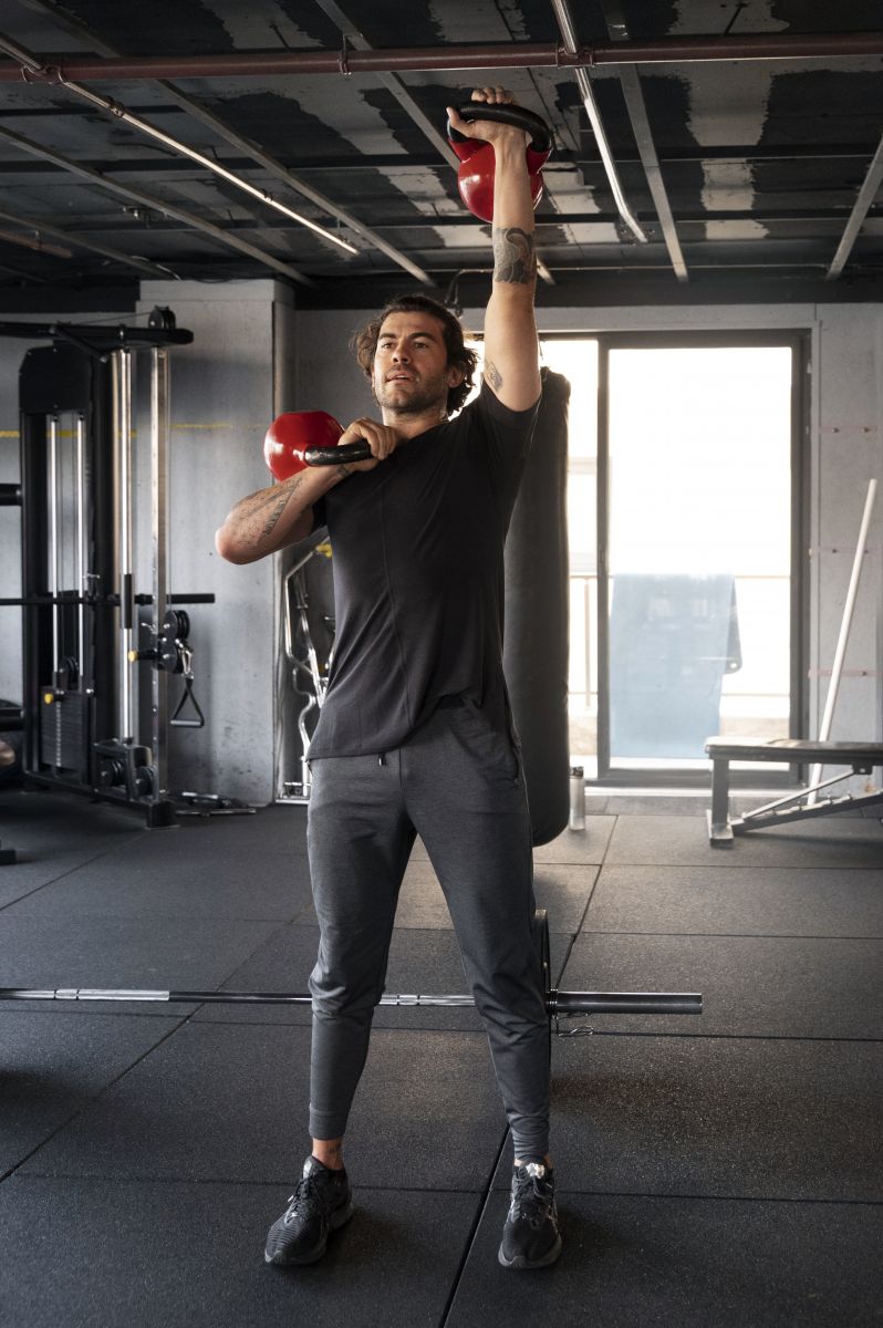 man lifting kettlebells